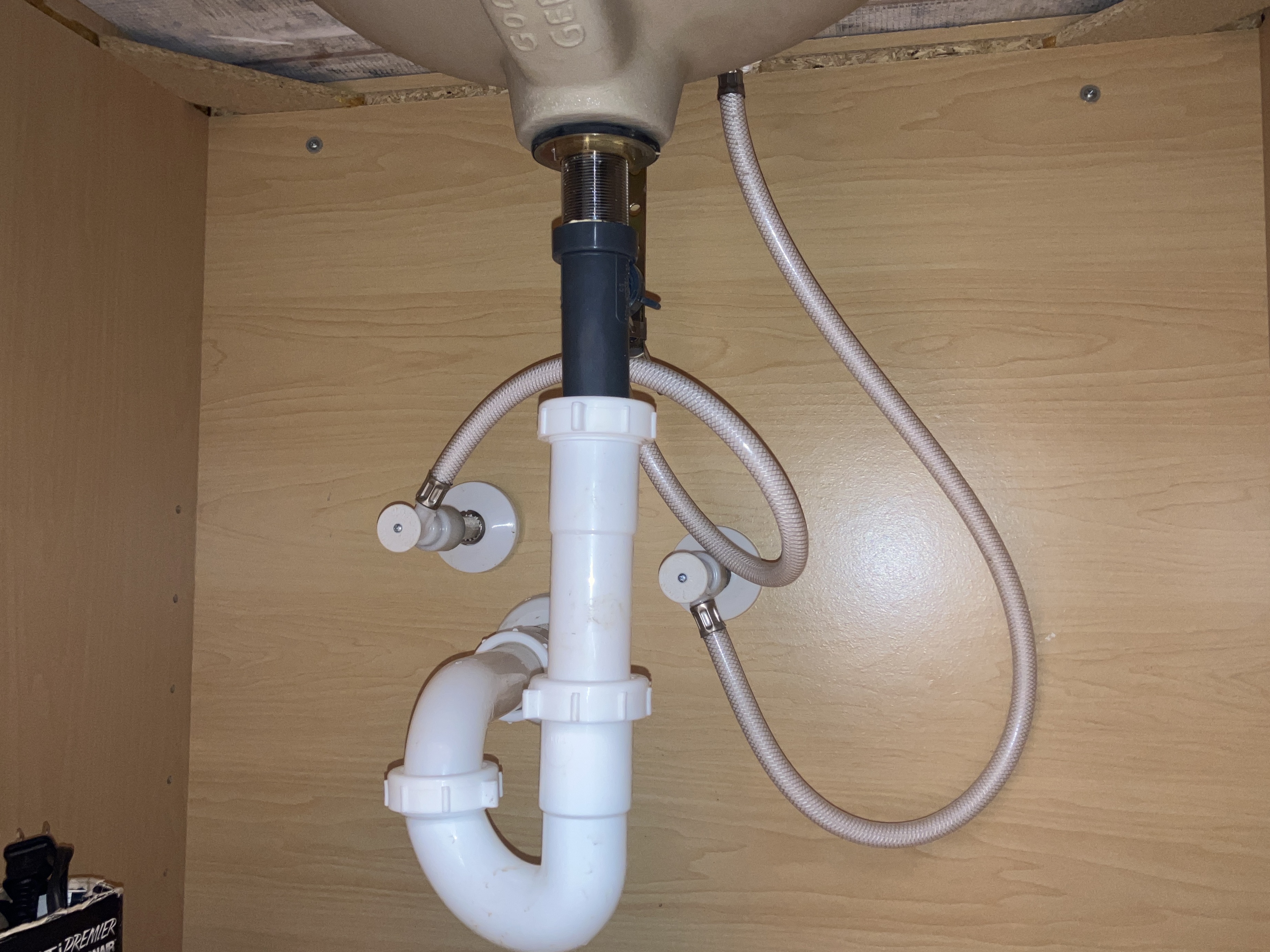 Plumbing supply lines under sink during four point inspection in Florida